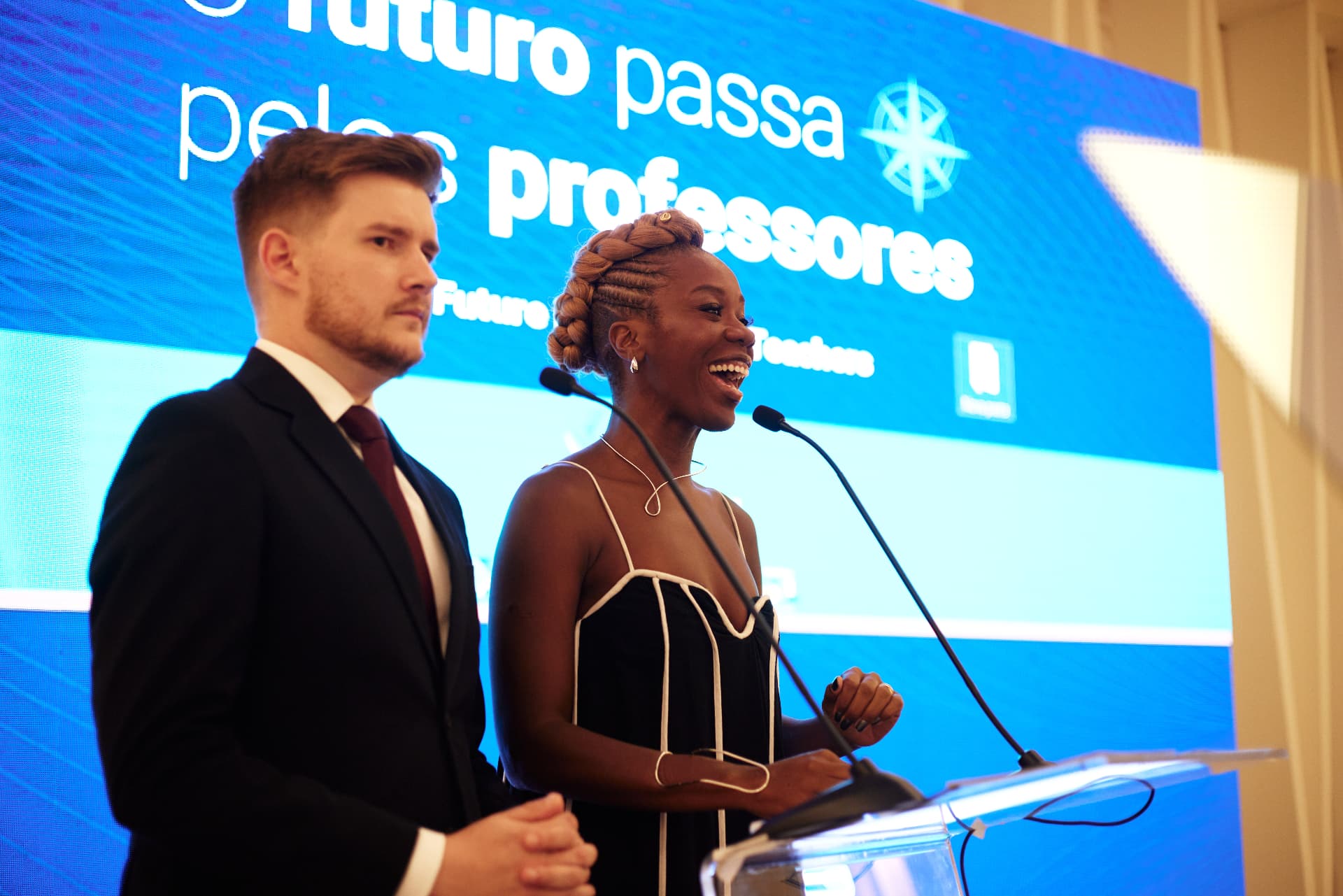 Apresentadores junto ao púlpito e aos microfones