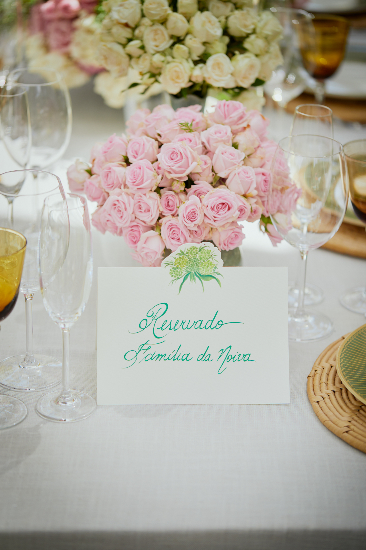 Rosas cor-de-rosa e brancas junto à mesa reservada para a família da noiva